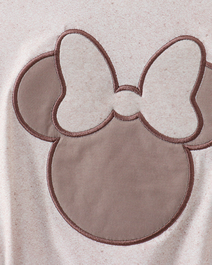 Close-up of a beige fabric with a bow and ear design, likely from a children&