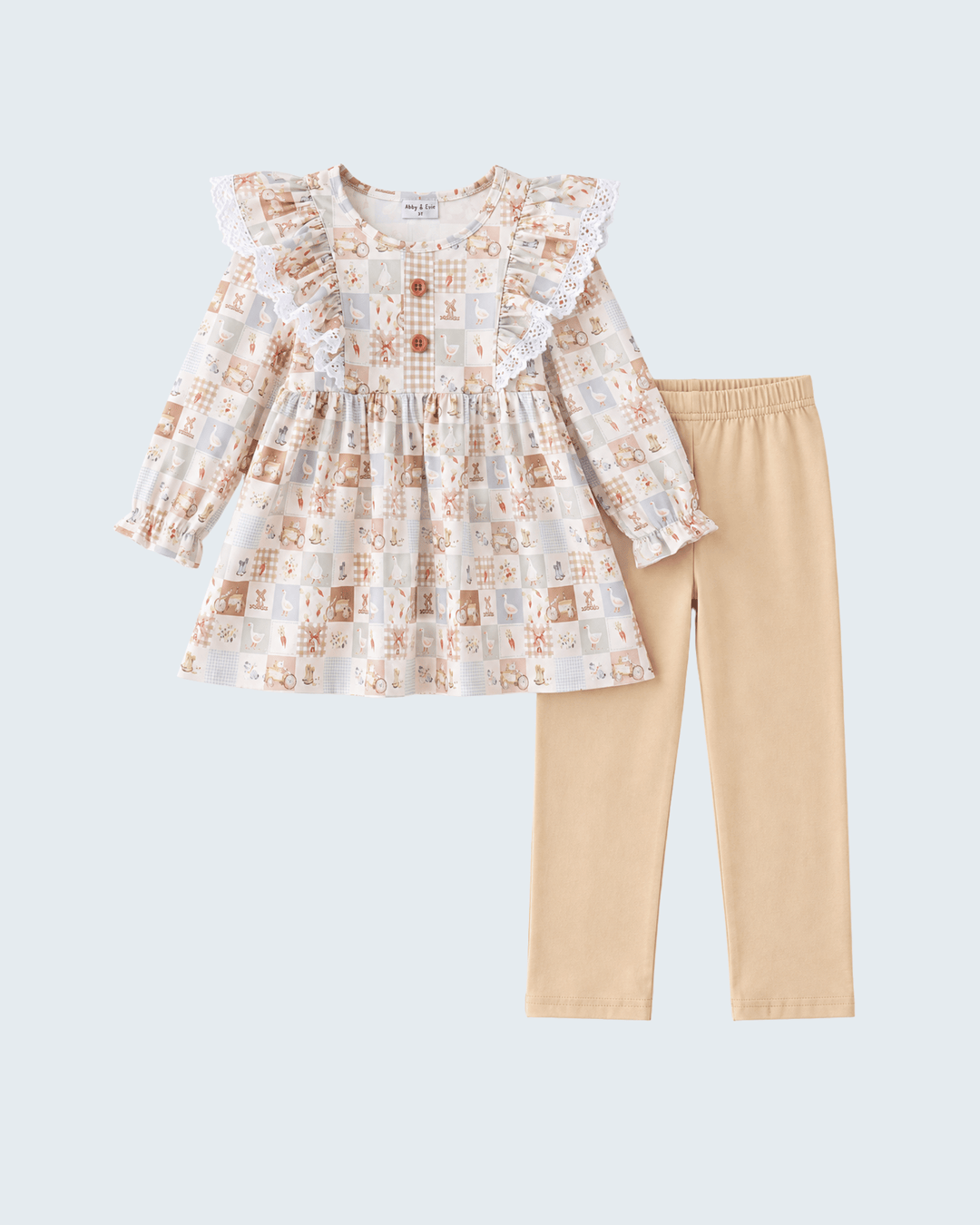 A toddler girl's two-piece outfit set featuring a long-sleeve ruffle-trimmed blouse with a beige, brown, and white patchwork print, paired with solid light beige leggings, shown on a light gray background.