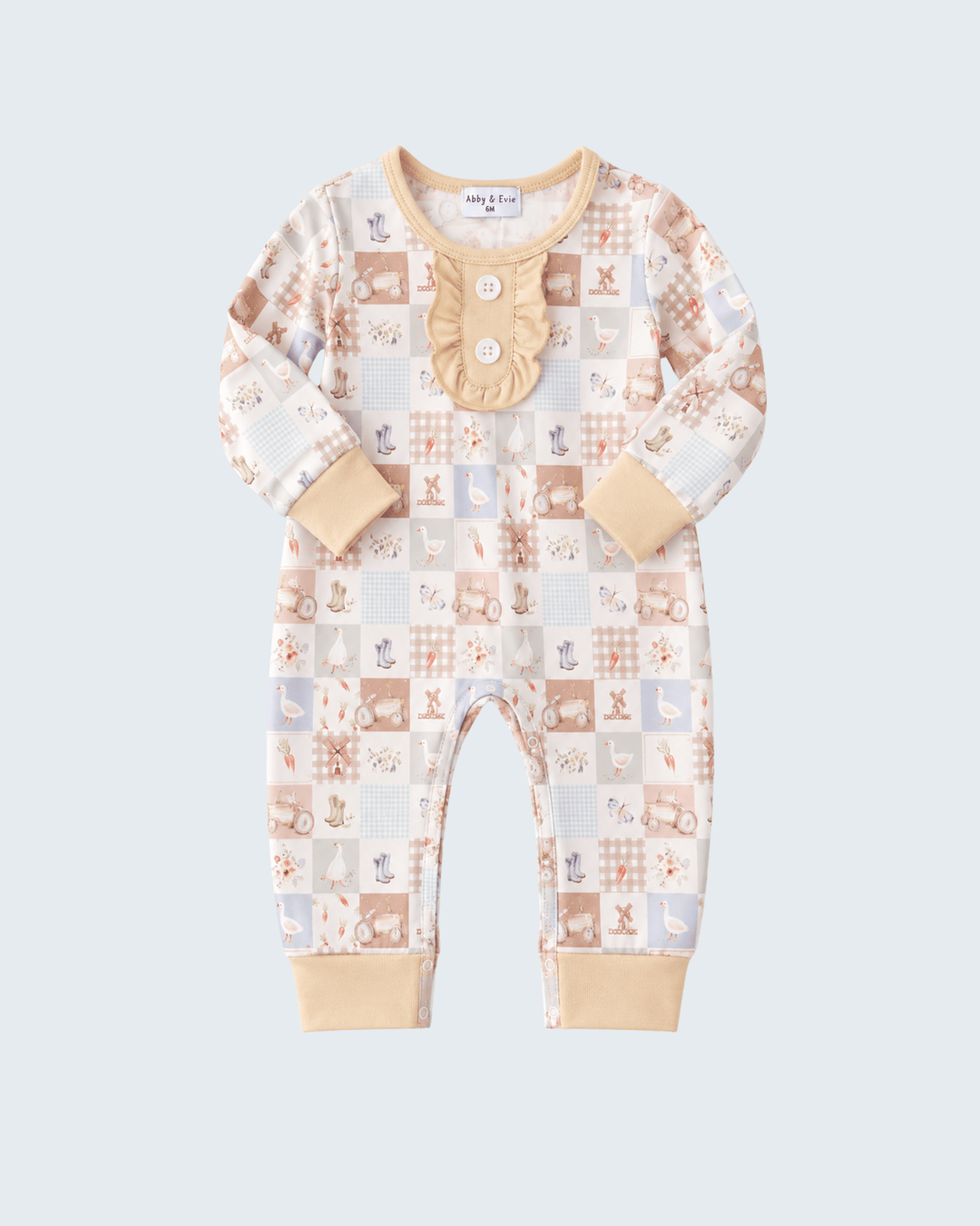 A baby long-sleeve footless romper in a beige and light blue patchwork animal print, featuring a decorative beige applique on the chest with a button closure, set against a solid light gray background.
