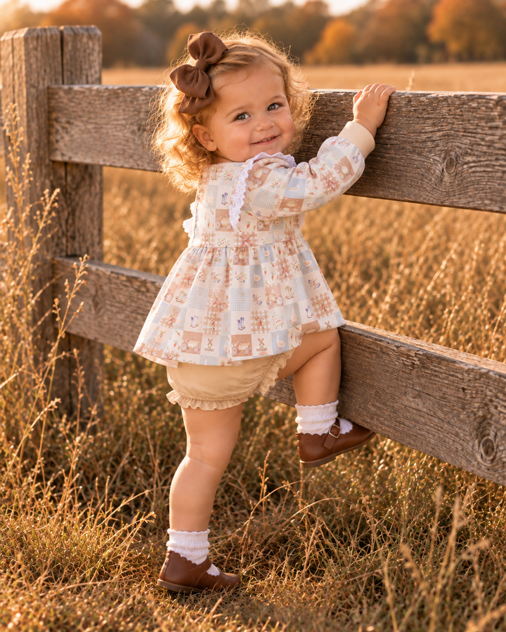 Toddler girl is trying to climb a wooden fence.