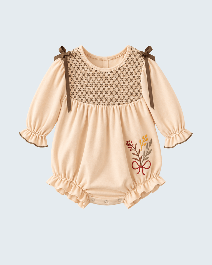 Light beige smocked embroidered bubble romper with puff sleeves and bow shoulder ties