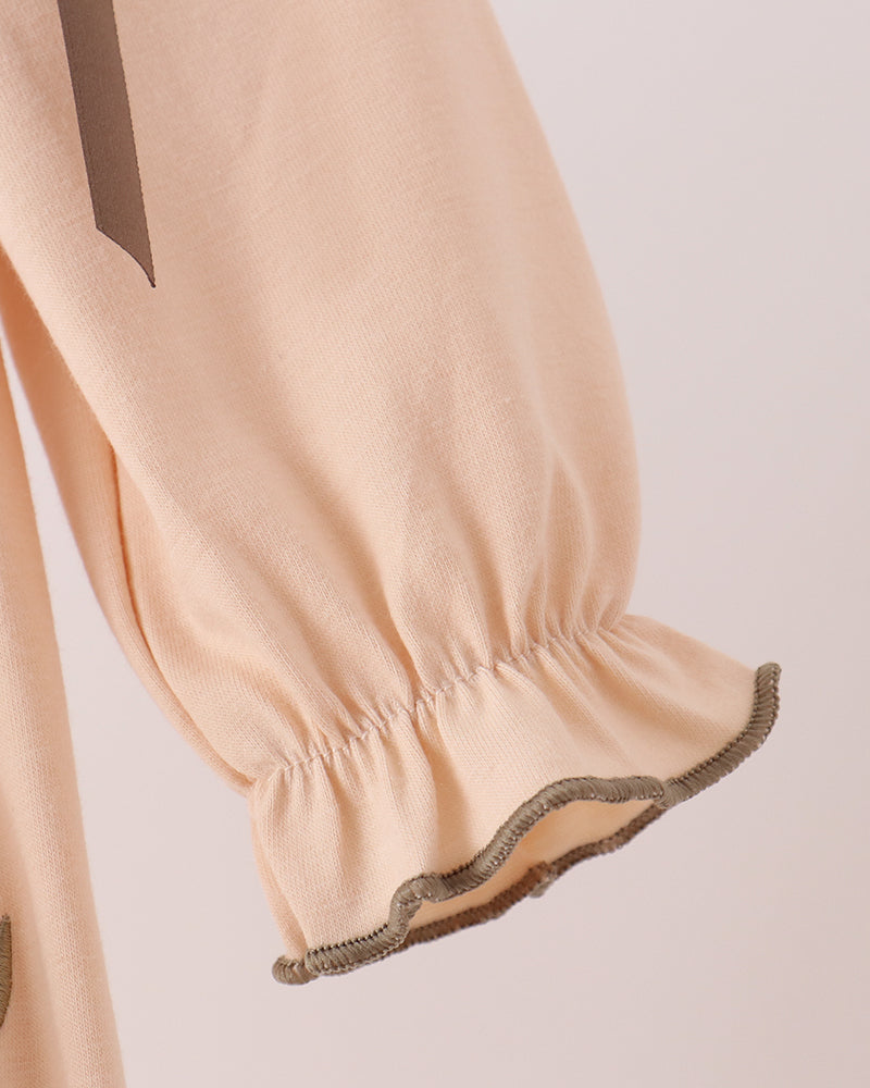Beige bubble romper with elasticated ruffle hem and dark contrast edge trim