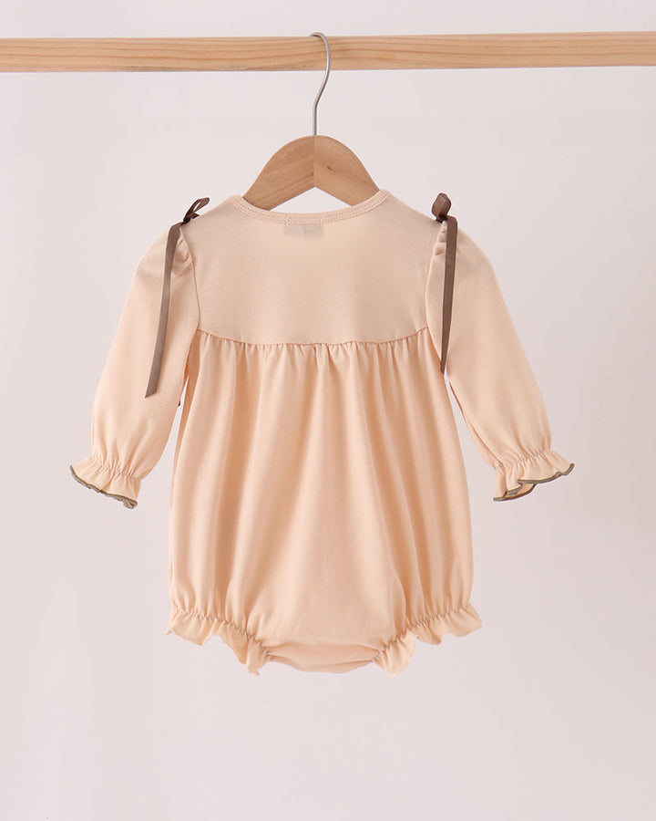Beige floral smocked bubble romper, back view with long sleeves and bow ties
