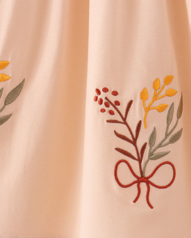 Beige dress with orange floral embroidery and gathered skirt hem