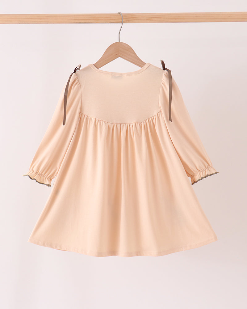 Beige floral smocked dress with long sleeves and gathered skirt