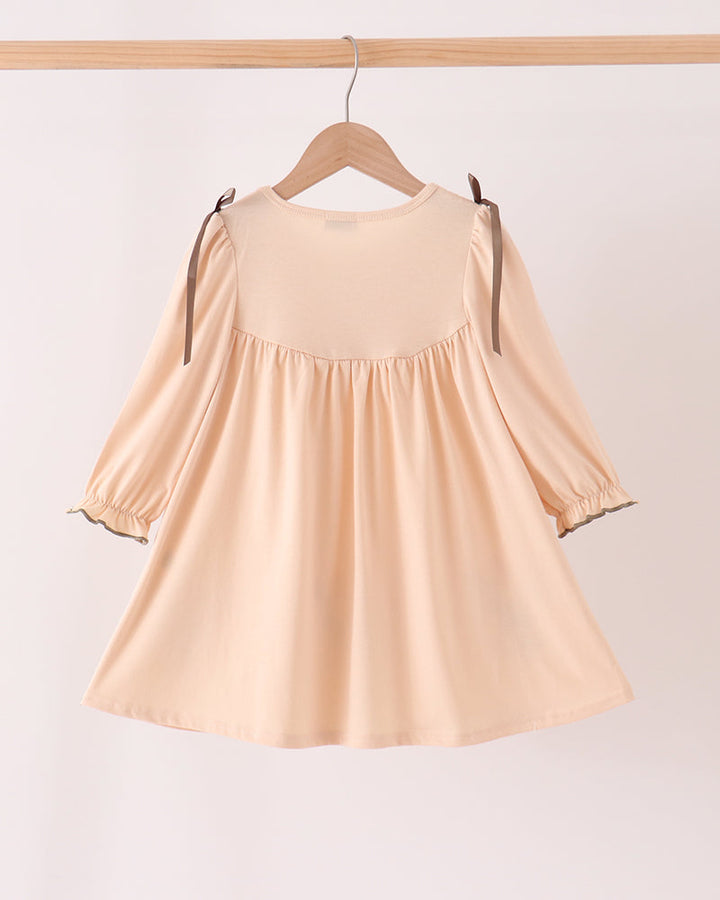 Beige floral smocked dress with long sleeves and gathered skirt