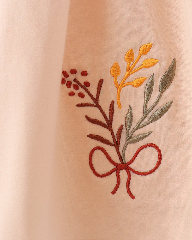 Beige embroidered floral applique on smocked ruffle top