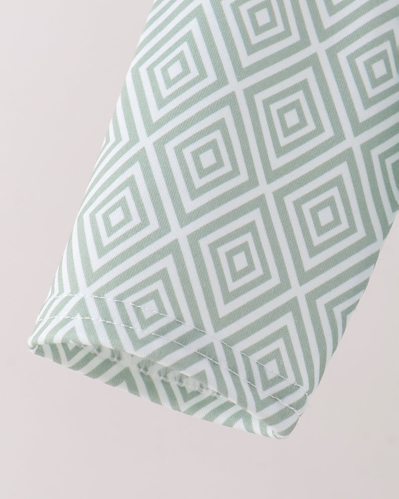A close-up of a folded sleeve, featuring a mint green and white geometric diamond pattern.