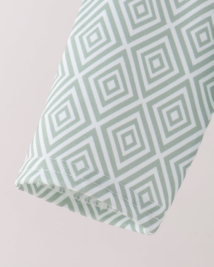 A close-up of a folded sleeve, featuring a mint green and white geometric diamond pattern.