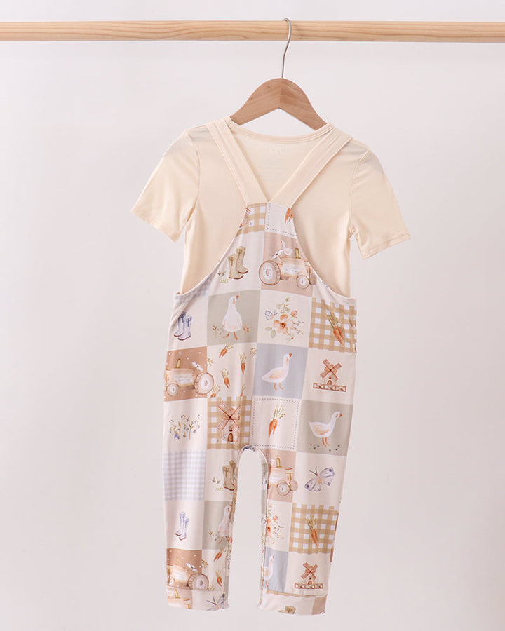Baby romper set with cream T-shirt and printed bib overalls, animal and check pattern