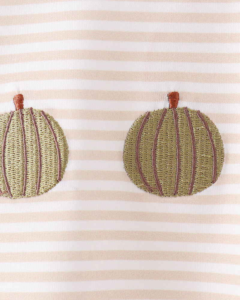Close-up of a striped fabric garment with two embroidered pumpkin appliqués in olive green and mauve, each with a small brown stem.