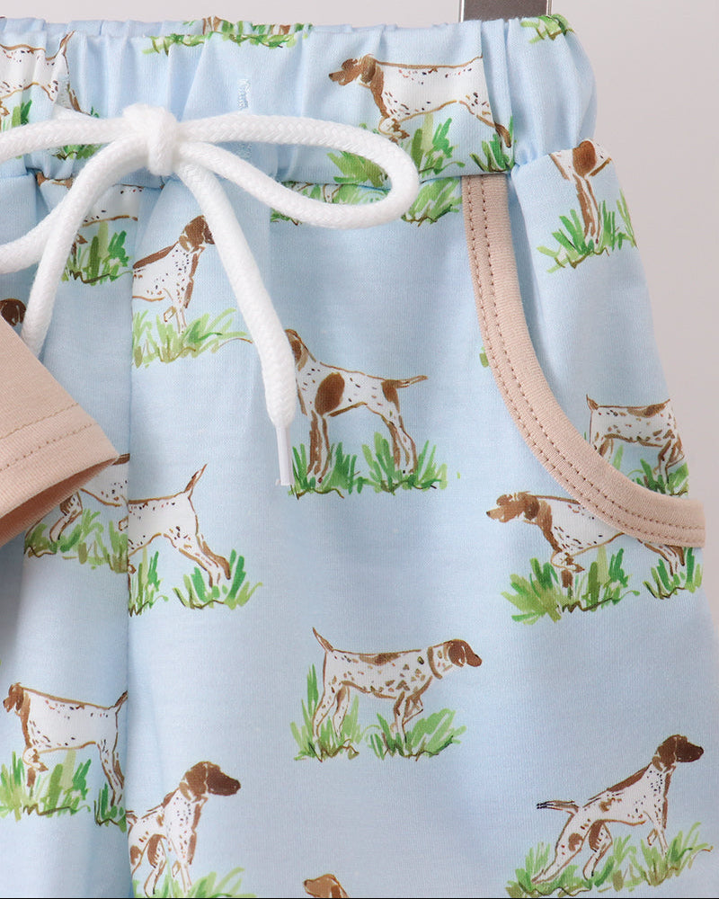 Drawstring bag with dog pattern on a hanger against a light blue background