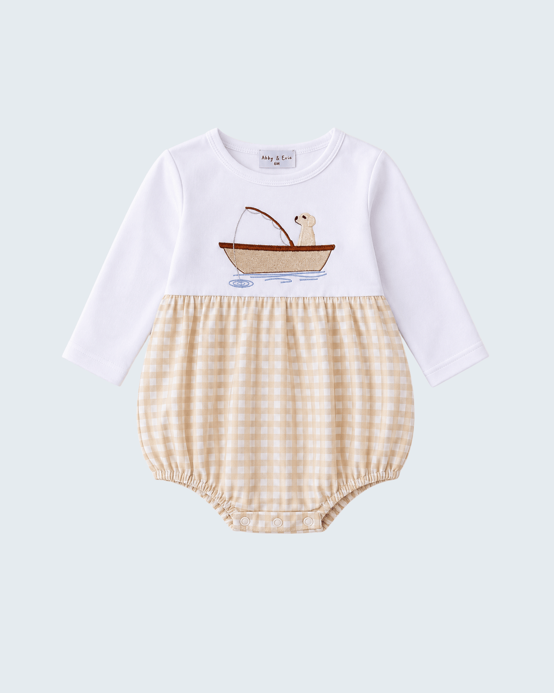 A baby long-sleeve romper with a white upper section featuring an embroidered boat-and-seal graphic, and a beige-and-white gingham check lower section, shown on a light gray background.