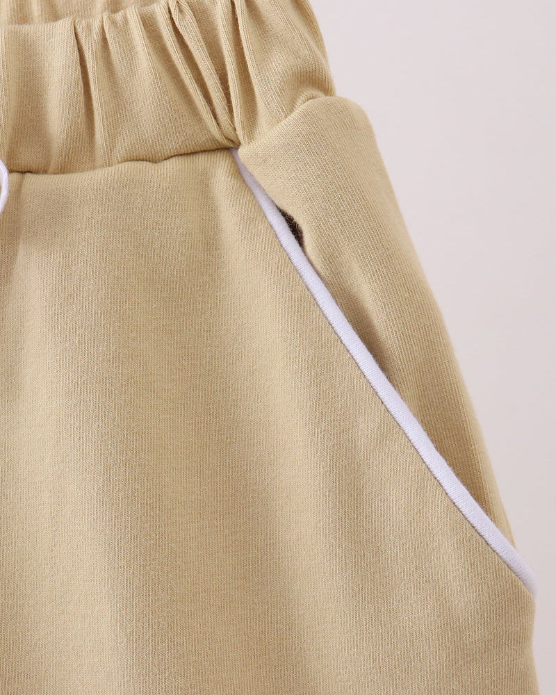 Light khaki skort with white side trim and angled panel detail at waist