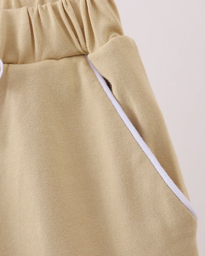 Light khaki skort with white side trim and angled panel detail at waist