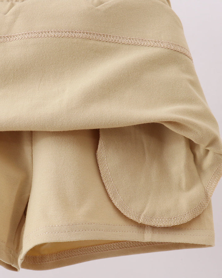 Light khaki skort with scalloped hem and rounded pocket opening panel