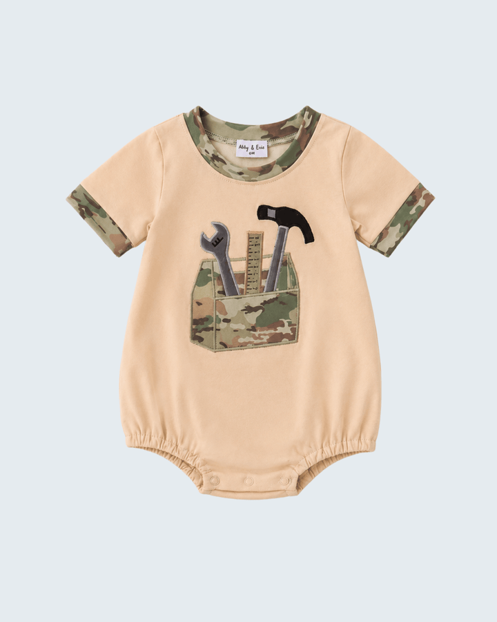Beige baby romper with tool design on a light blue background