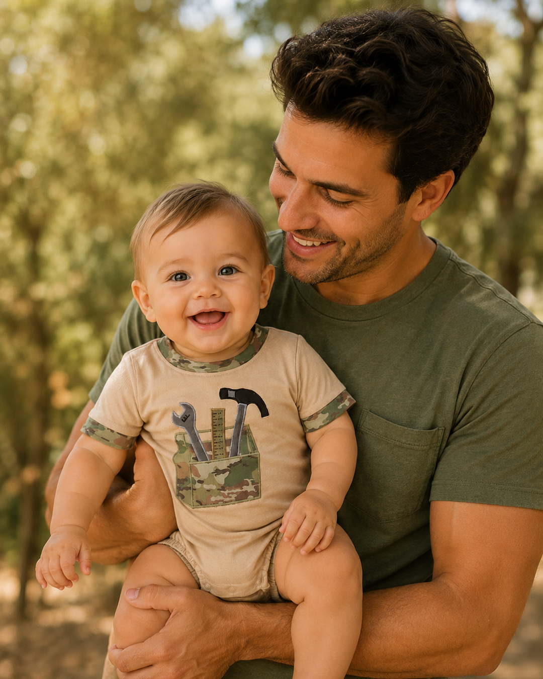 Man holding a baby outdoors with trees in the background
