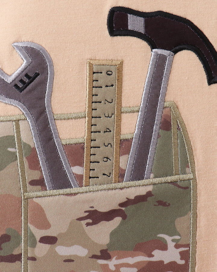 Camouflage tool belt with tools including a wrench, hammer, and ruler.