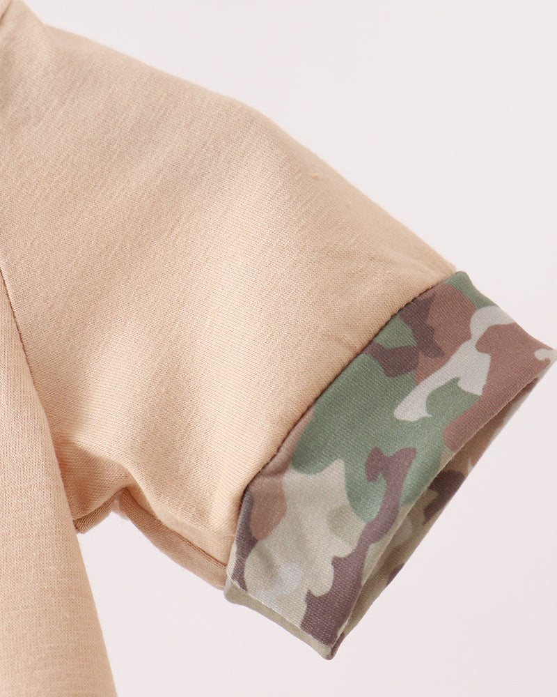 Close-up of beige sleeve with camouflage cuff on a light gray background