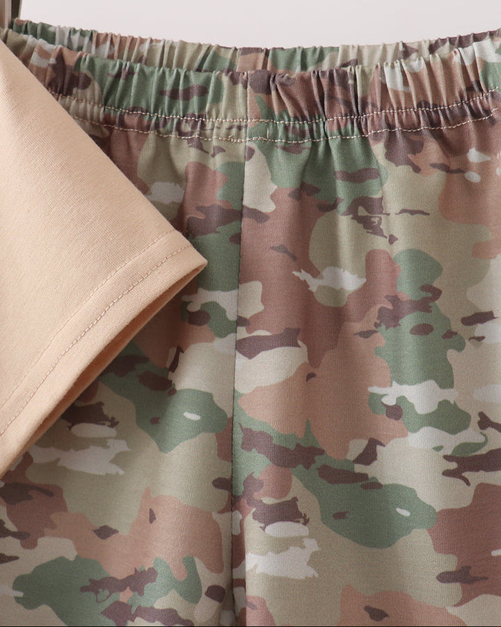 Camouflage shorts on a wooden hanger with a white background