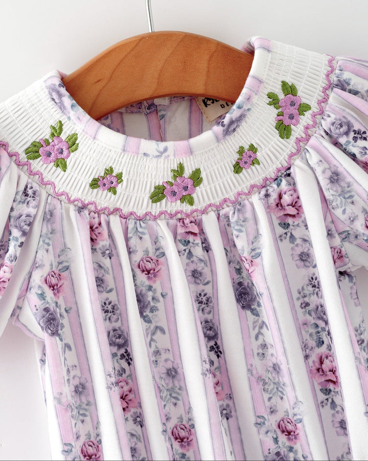Baby girl romper close-up: smocked neckline with green flower embroidery, lavender striped print