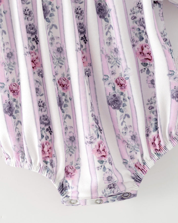 Baby girl romper close-up: lavender striped floral print with elastic leg openings