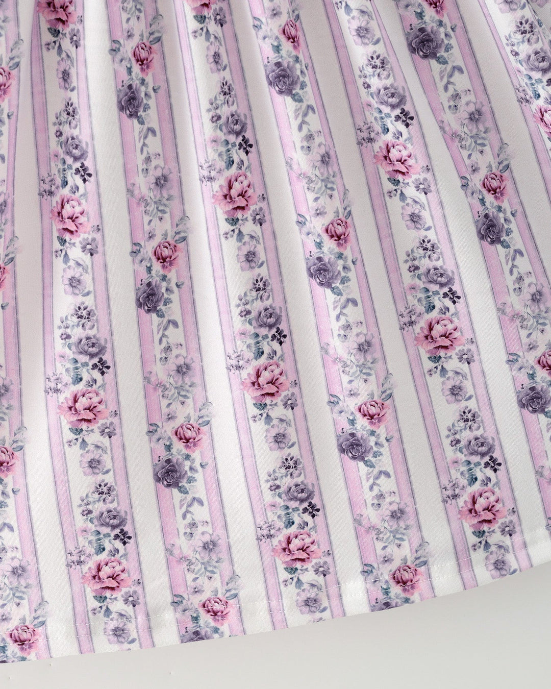 Close-up of girls floral striped dress fabric with pink and purple flower print