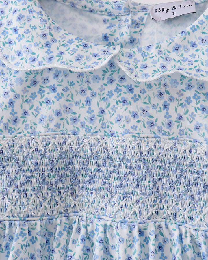 Floral smocked yoke dress with round ruffled neckline and long sleeves, light blue