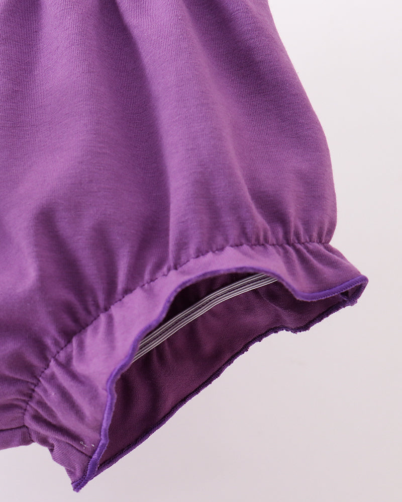 Close-up of a purple garment with a zipper on a light gray background