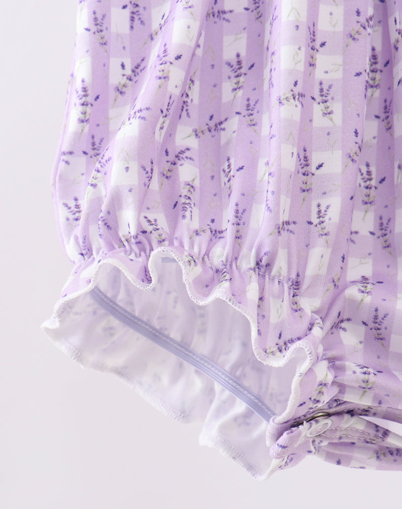 Close-up of a purple floral dress with ruffled hem on a light gray background