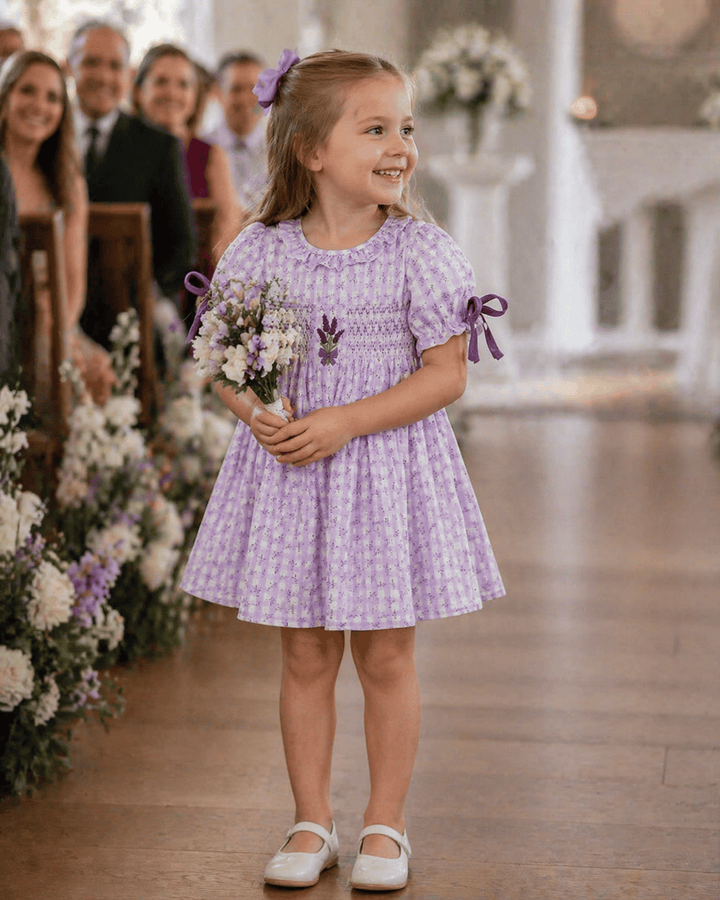 Young girl in a purple dress holding flowers in a decorated hallway