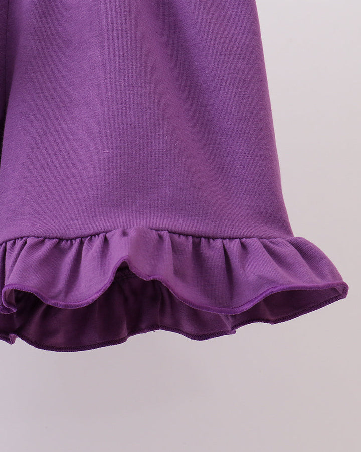 Purple dress with ruffled hem on a light gray background