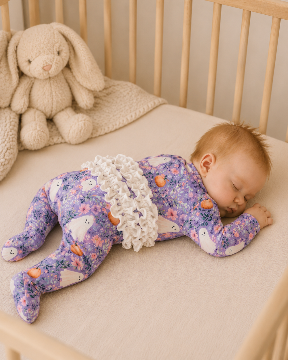 Lavender floral footed romper with ruffle trim and ghost and pumpkin prints on long sleeves