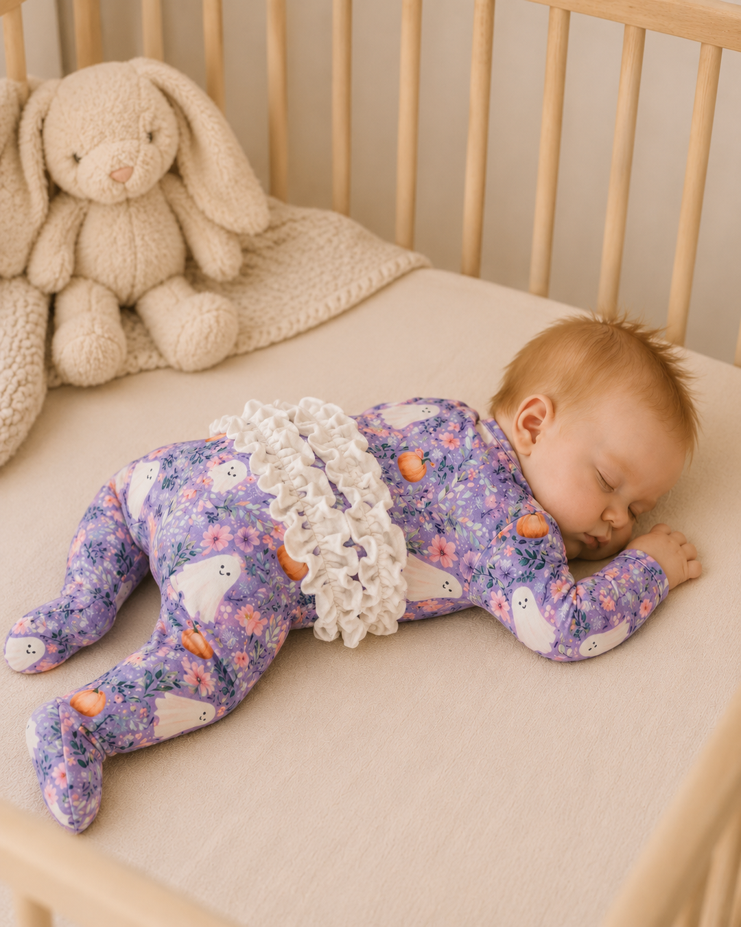 Lavender floral footed romper with ruffle trim and ghost and pumpkin prints on long sleeves