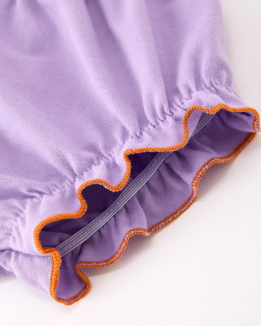 Lavender bloomers with gathered waistband and orange-edged ruffle trim