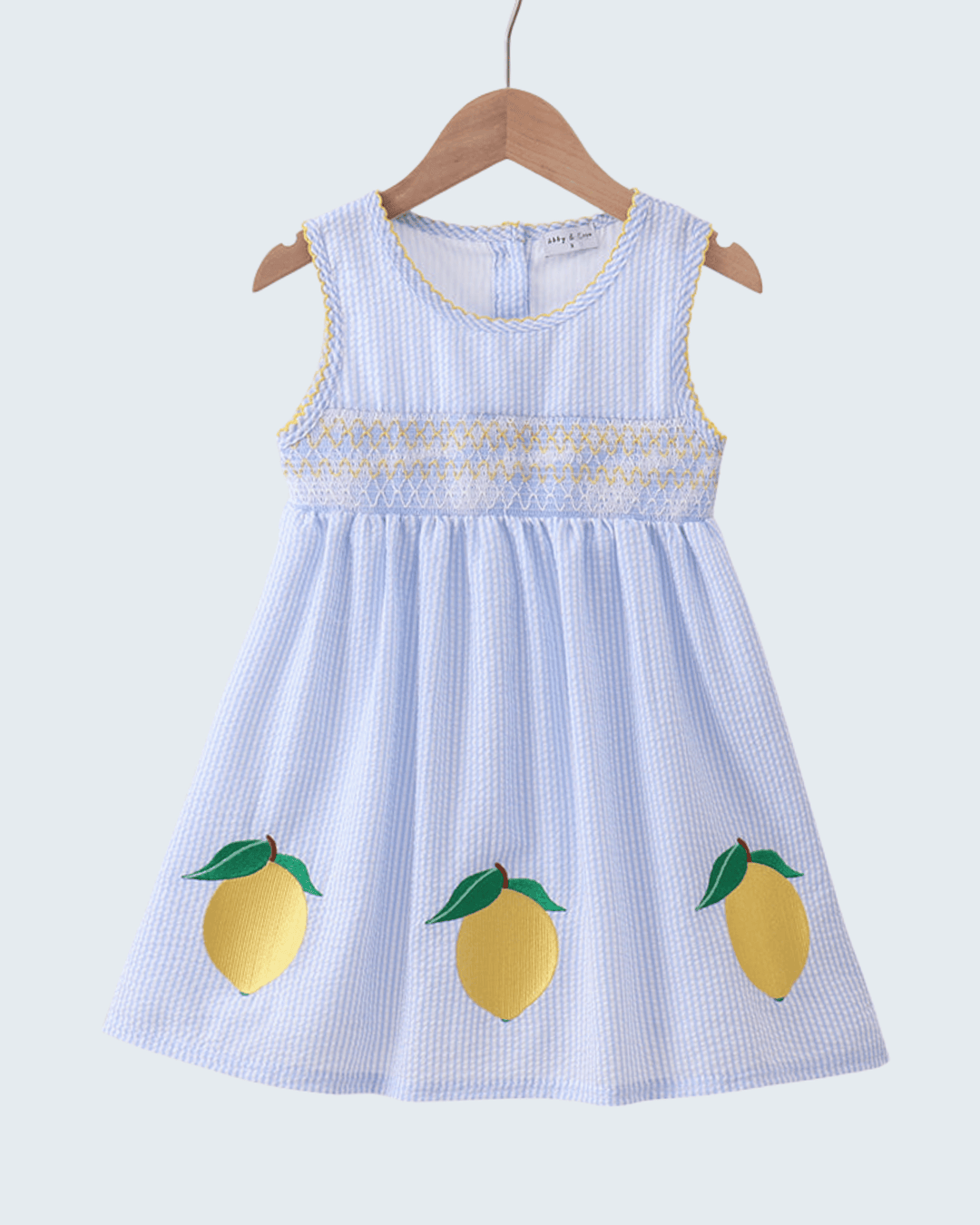 Children's dress with lemon designs on a white background