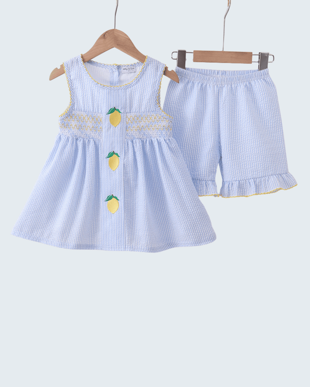 Children's blue striped dress and shorts set with lemon designs on a white background
