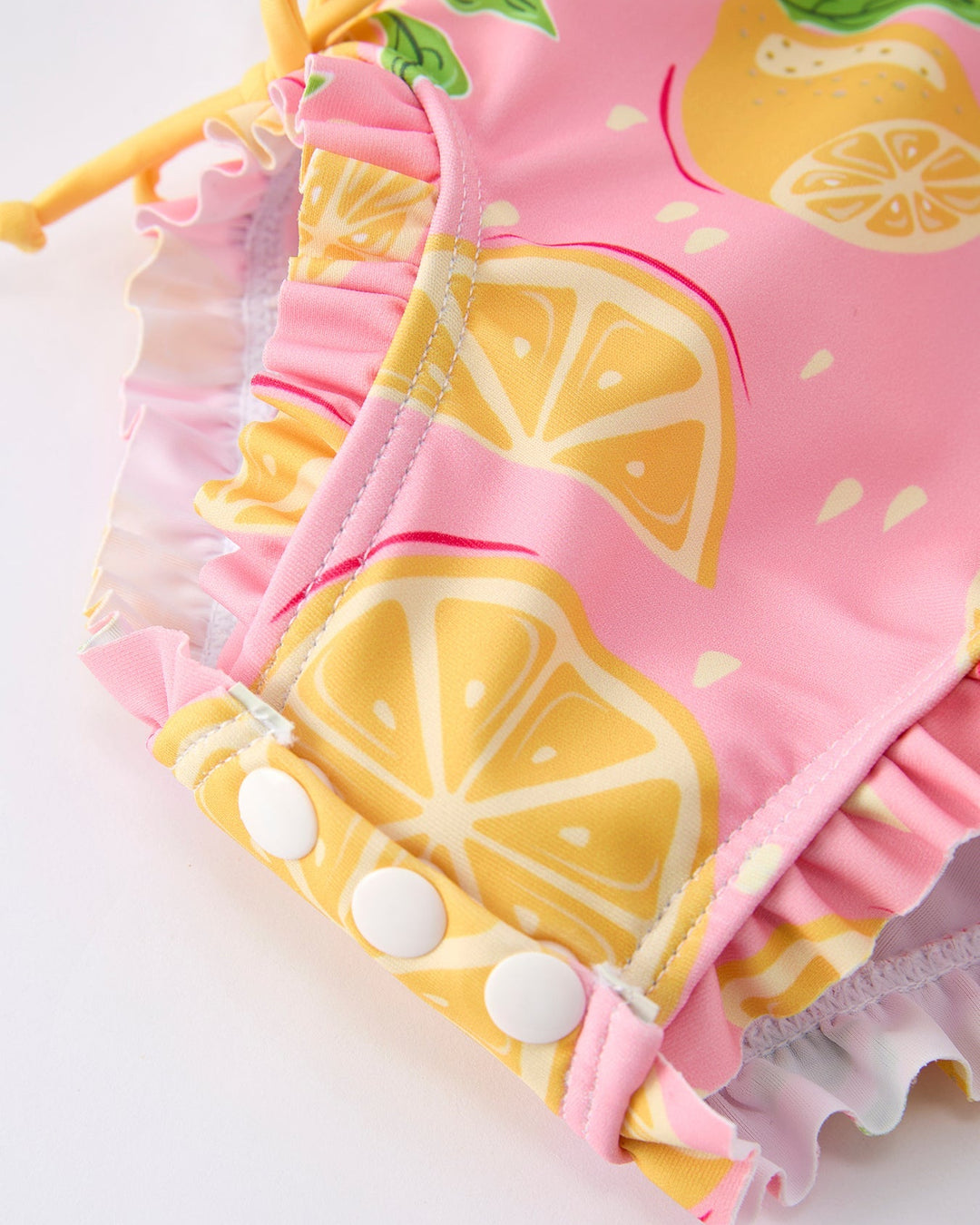 Pink baby bloomers with lemon pattern on a white background
