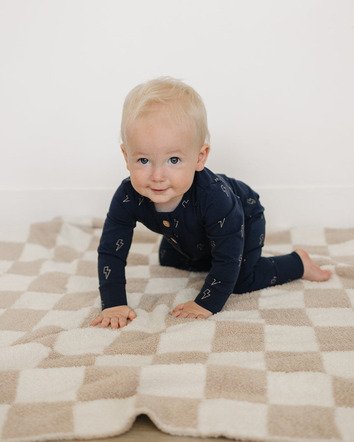 Navy lightning-print button-front baby romper worn by toddler, long sleeves, snap legs