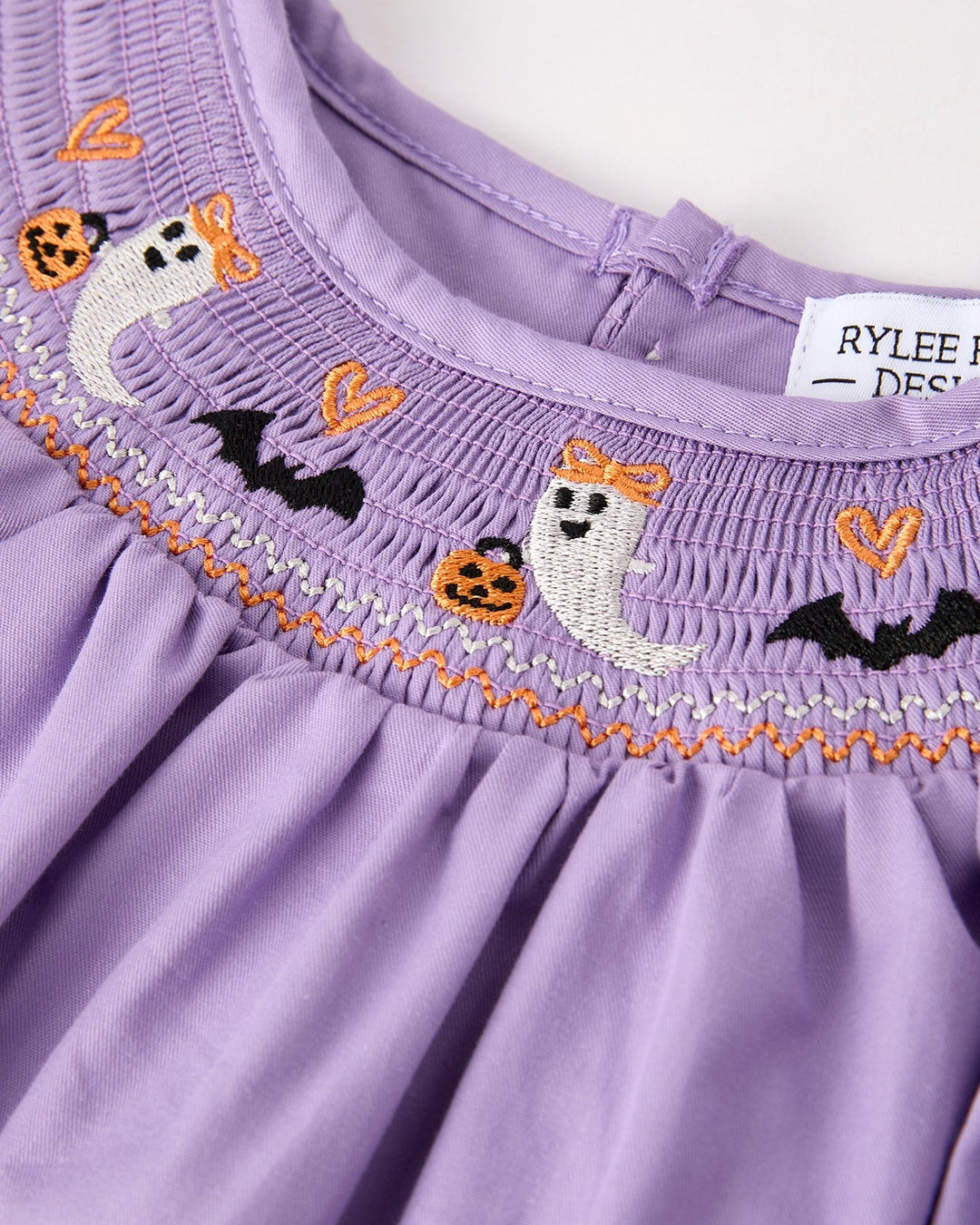 Lavender yoke with orange stitched trim and embroidered ghost, cat, and bat motifs