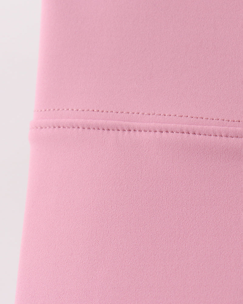 Close-up of a pink fabric with stitching detail on a white background