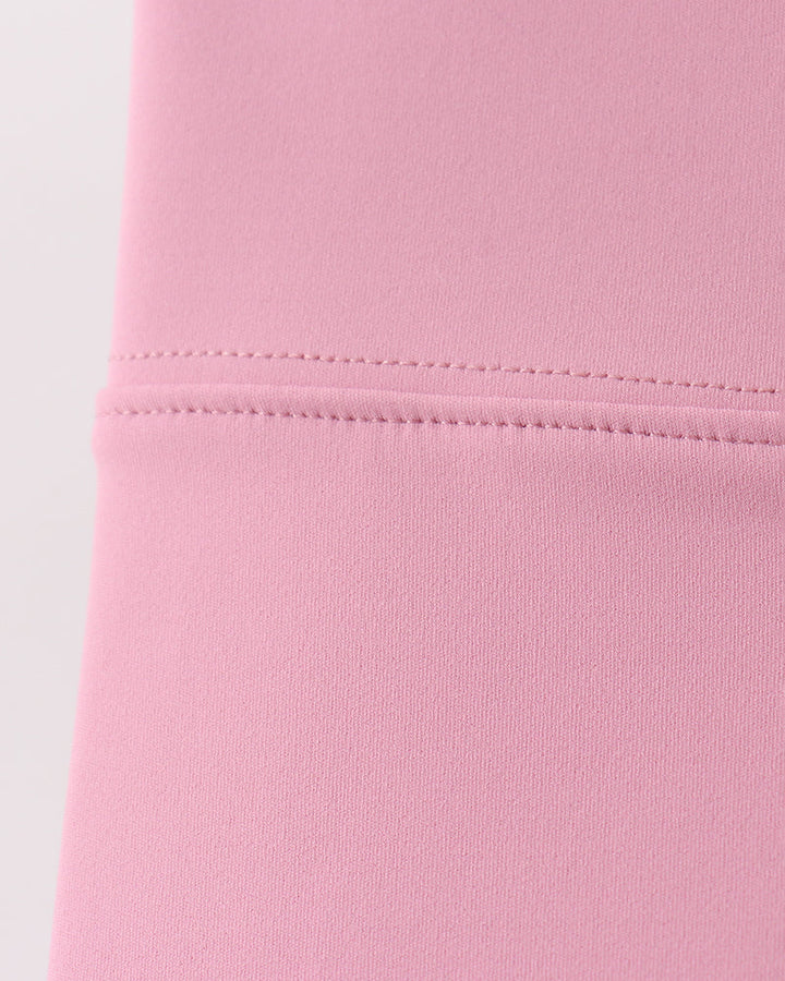Close-up of a pink fabric with stitching detail on a white background