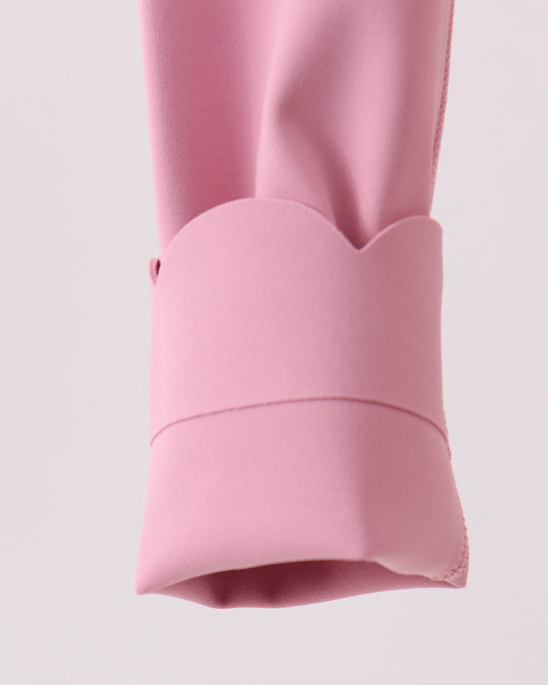 Close-up of a pink legging with a cuff on a light pink background