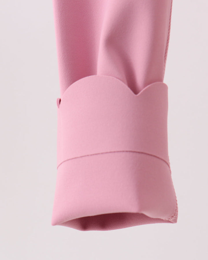 Close-up of a pink legging with a cuff on a light pink background