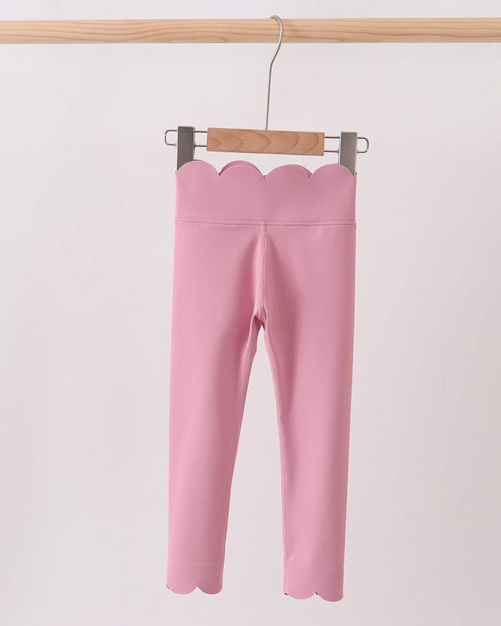 Pink leggings on a hanger against a light pink background