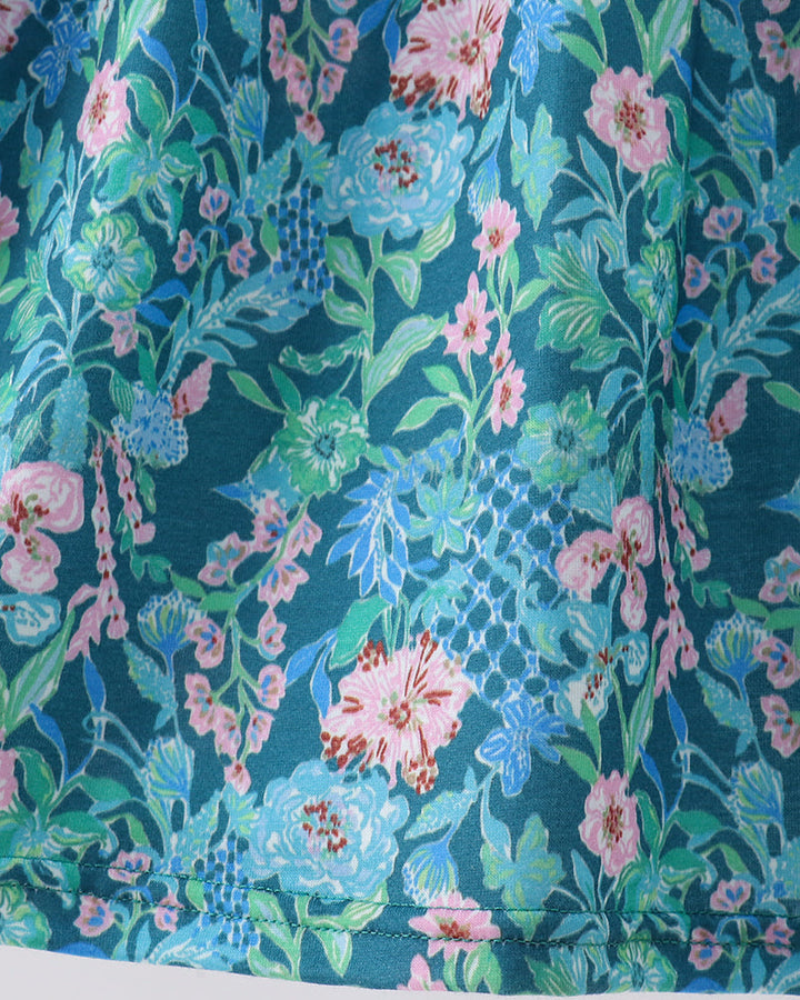Lily floral dress fabric close-up: teal with pink, blue, and white blossom pattern