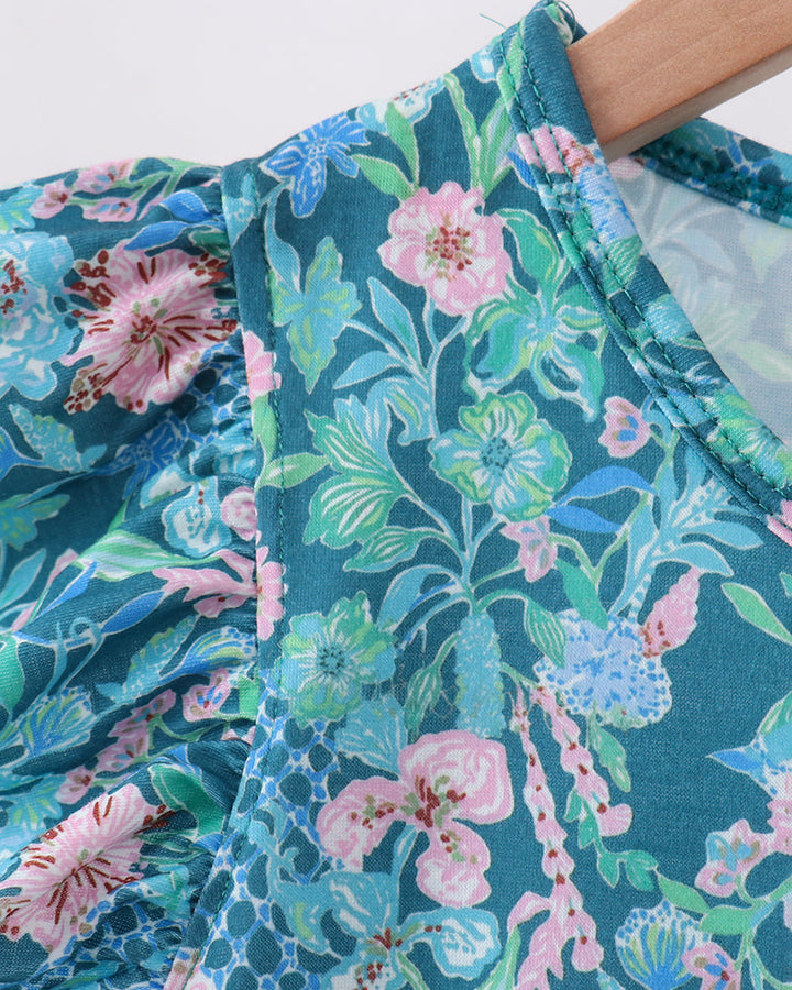 Lily floral dress neckline close-up: teal floral print with flutter sleeve ruffle trim