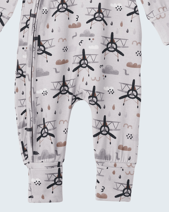 Bamboo zipper romper, close-up of allover graphic print on pale fabric, footed legs.