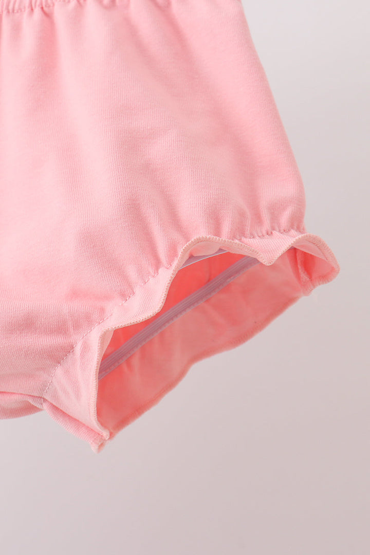 Pink bloomers with elastic waistband and ruffled leg hem, close-up